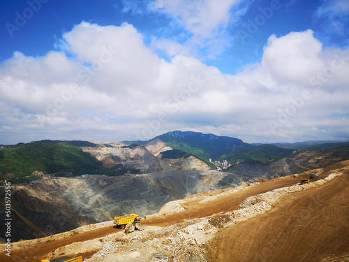 View of the cars on the mine against the mountains range and blue sky. Majdanpek, Serbia. photo