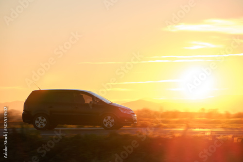 SUV car driving fast on intercity road at sunset. Highway traffic in evening © bilanol