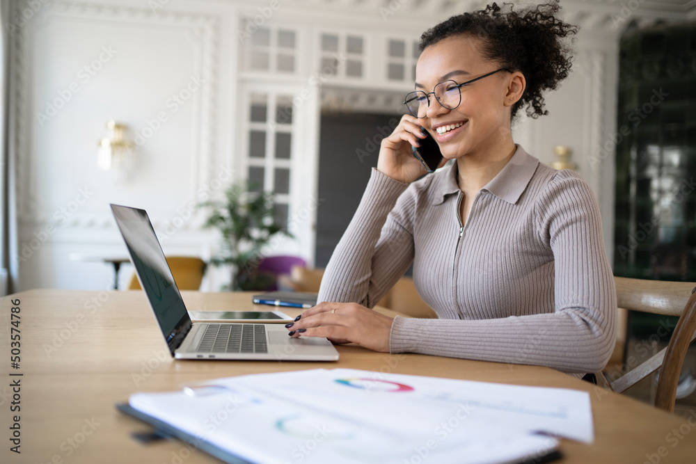 Communication online video communication with colleagues. A freelancer woman working in a modern office uses a laptop. Communication online video communication with colleagues. A freelancer woman working in a modern office uses a laptop.