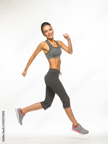 athletic girl in training clothes posing on a white background in the studio in full growth 