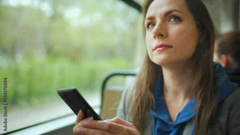 Woman in tram using smartphone chatting and texting with friends. City, urban, transportation. Woman in tram using smartphone chatting and texting with friends. City, urban, transportation.
