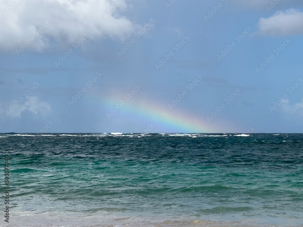 rainbow on the beach over blue green waters of the Atlantic Ocean in the West Indies 