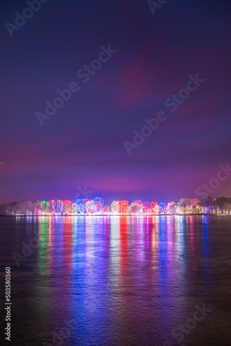 christmas lights in the city reflecting the icy lake in the winter