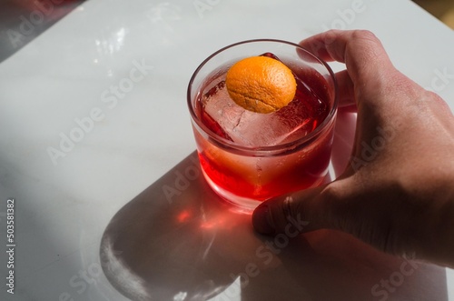 red cocktail with orange peel