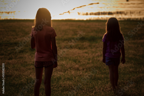 sisters on lake at sunset