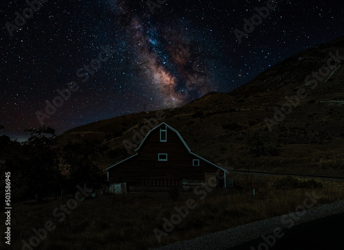 The Milky Way over a barn in the mountains