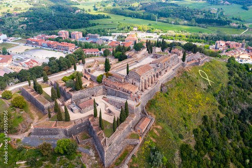 Panoramic aerial view of medieval walled fortress on top of basalt hill in Hostalric village in spring, Catalonia, Spain.
