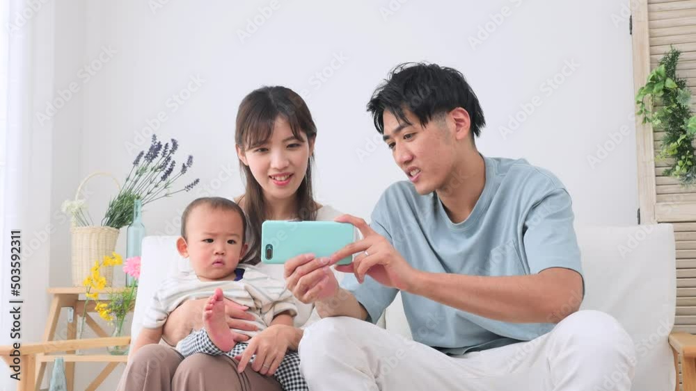 両親と赤ちゃん　スマホ　リビング