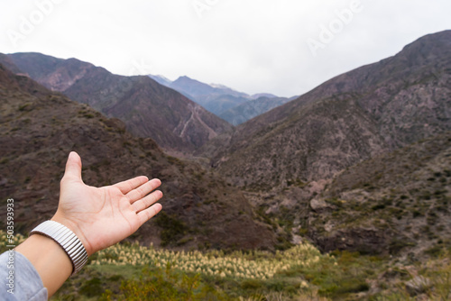 hand offering the view of wonderful mountains, concept of nature, travel, outdoors, well-being
