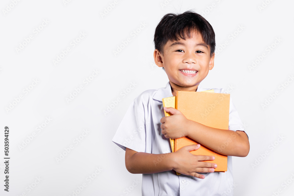 Asian adorable toddler smiling happy wear student thai uniform red pants stand hold or hugging book in studio shot isolated on white background, Portrait little children boy preschool, Back to school Asian adorable toddler smiling happy wear student thai uniform red pants stand hold or hugging book in studio shot isolated on white background, Portrait little children boy preschool, Back to school