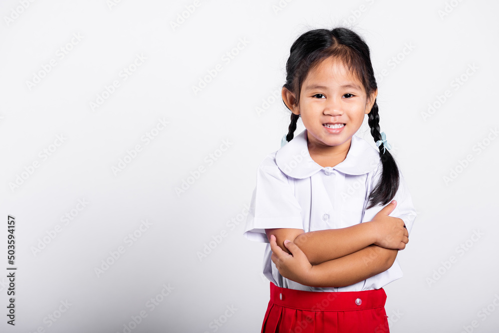 Asian toddler smile happy wearing student thai uniform red skirt stand with arms folded in studio shot isolated on white background, Portrait little children girl preschool crossed arm, Back to school Asian toddler smile happy wearing student thai uniform red skirt stand with arms folded in studio shot isolated on white background, Portrait little children girl preschool crossed arm, Back to school