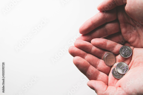 Coins in the palm of your hand. Poverty and depreciation. Minimum wage.