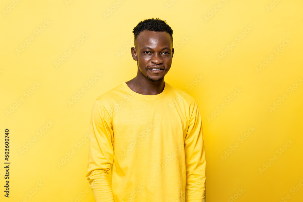 Young African man smiling on isolated yellow stuido background