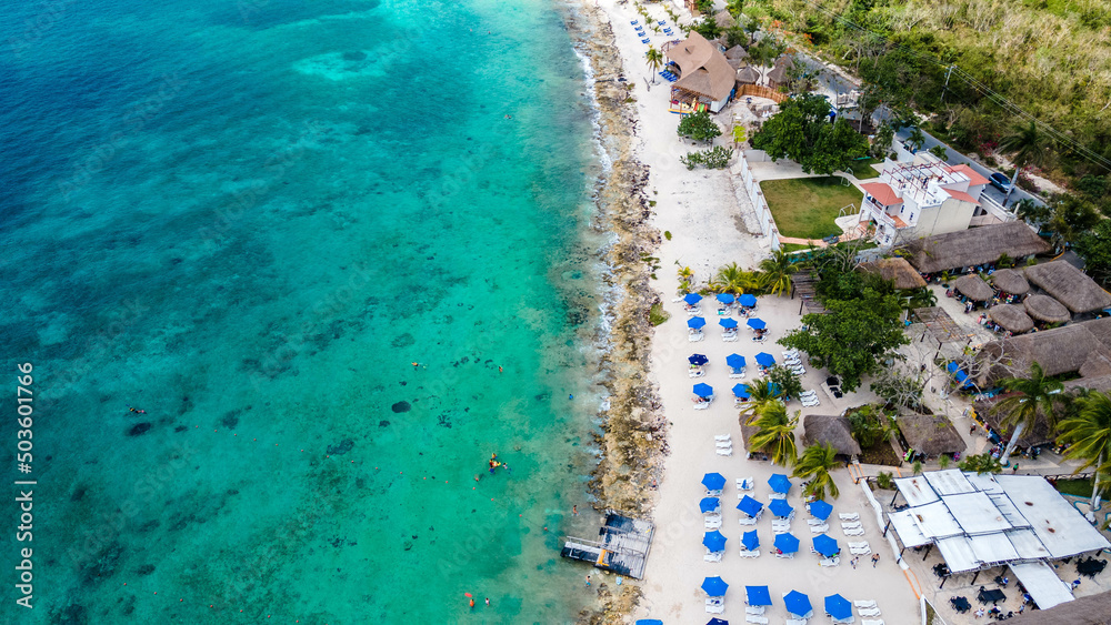 Overhead drone shot of swimmers on a tropical beach in Cozumel, Mexico.