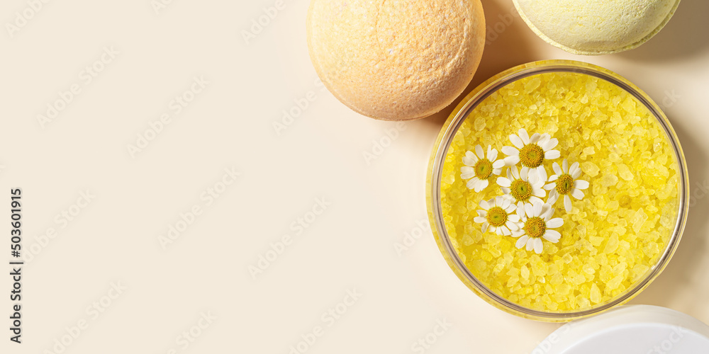 Bath salt sea and bath bomb with herbal extract of chamomile, sea salt crystals in jar, neutral beige spa background. Close up body care cosmetics, natural organic product, herbal medicine Bath salt sea and bath bomb with herbal extract of chamomile, sea salt crystals in jar, neutral beige spa background. Close up body care cosmetics, natural organic product, herbal medicine