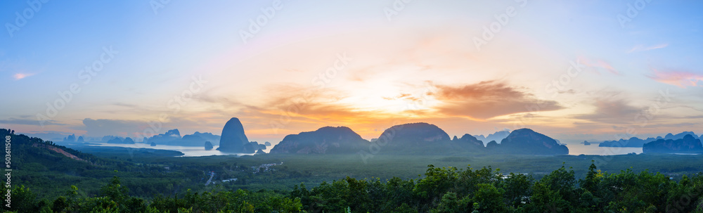 Atmosphere sunrise in the morning, sky is changing colors, there is a faded fog, the view of Phang Nga Bay is in front of a mangrove forest with mountains.