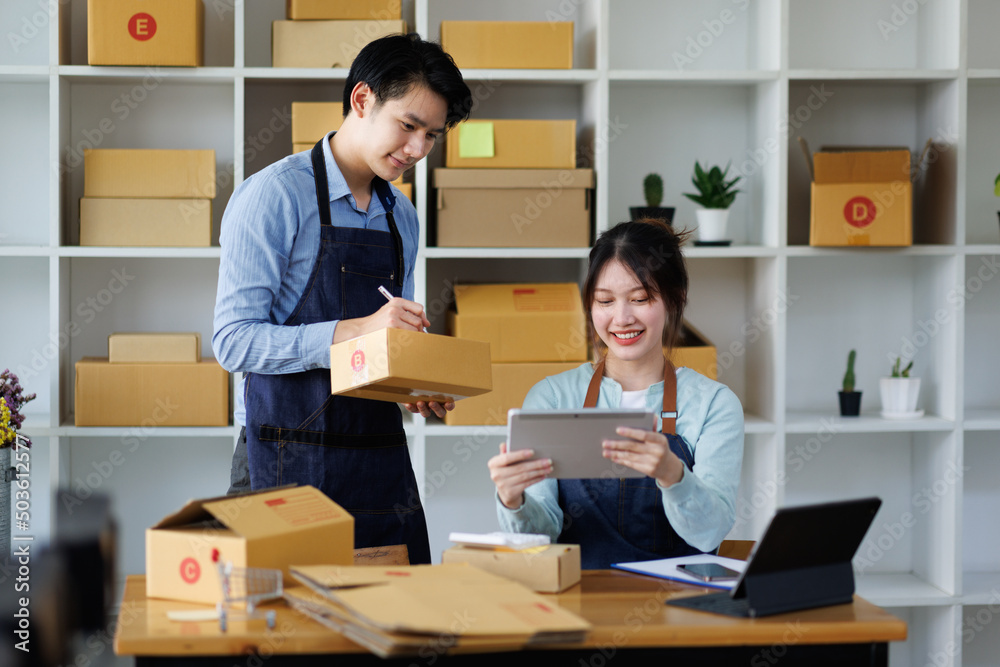 Asian guy and girl,SME Online business,Work at home concept,SME,Asian business couple,checking customer order online shipping,Work at home. Asian guy and girl,SME Online business,Work at home concept,SME,Asian business couple,checking customer order online shipping,Work at home.