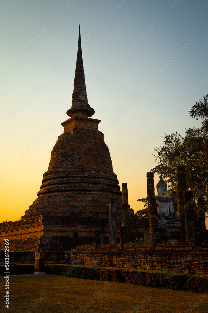Fototapeta premium Sunset at Wat Mahathat buddha and temple in Sukhothai Historical Park