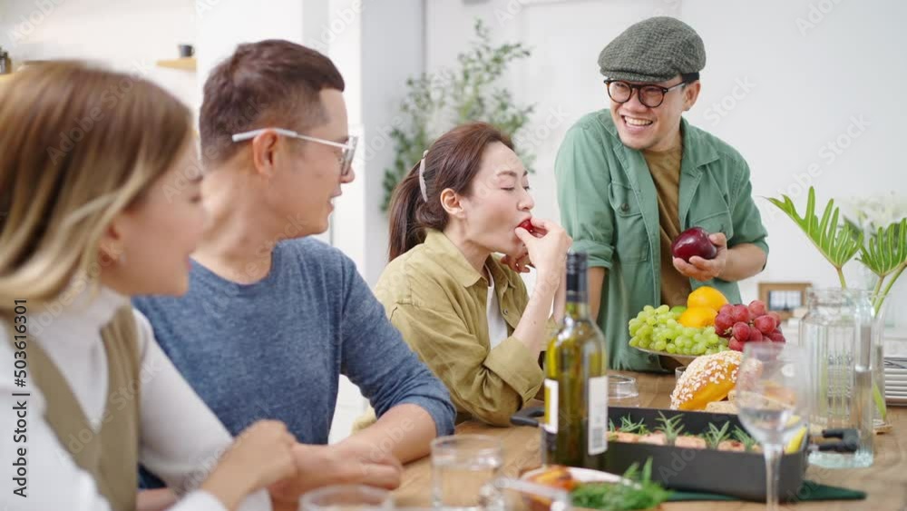 Group of Asian people friends enjoy dinner party eating food and drinking wine on the table with talking together at home. Happy man and woman reunion dinner meeting celebration on holiday vacation Group of Asian people friends enjoy dinner party eating food and drinking wine on the table with talking together at home. Happy man and woman reunion dinner meeting celebration on holiday vacation
