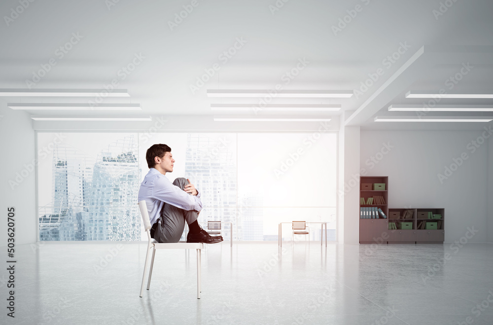 scared businessman on a chair in office scared businessman on a chair in office