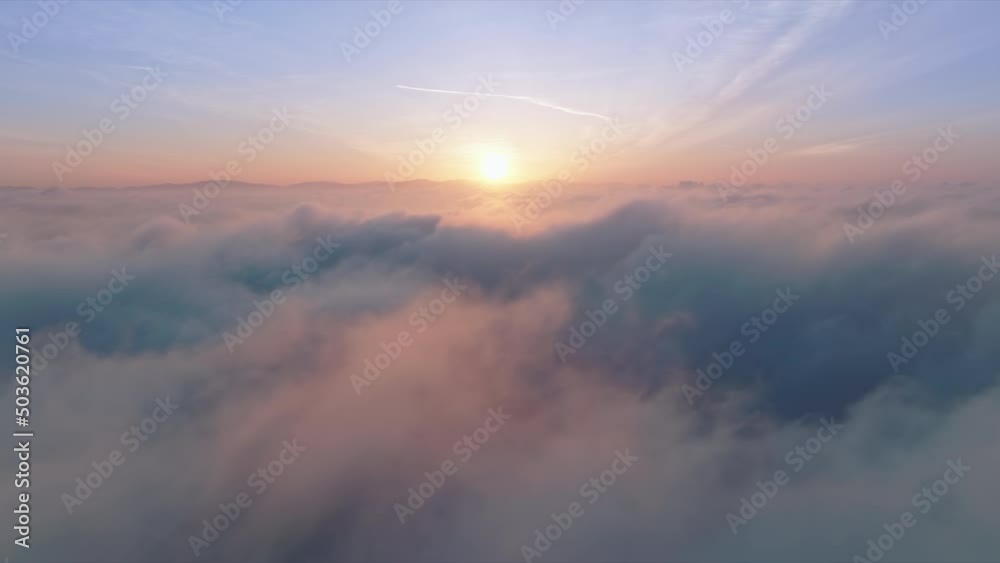 Nature environment background, paradise footage. 4K aerial majestic sunrise above amazing cloudscape with sun light heavenly shining through golden clouds. Paradise clouds slow motion at pink sunset