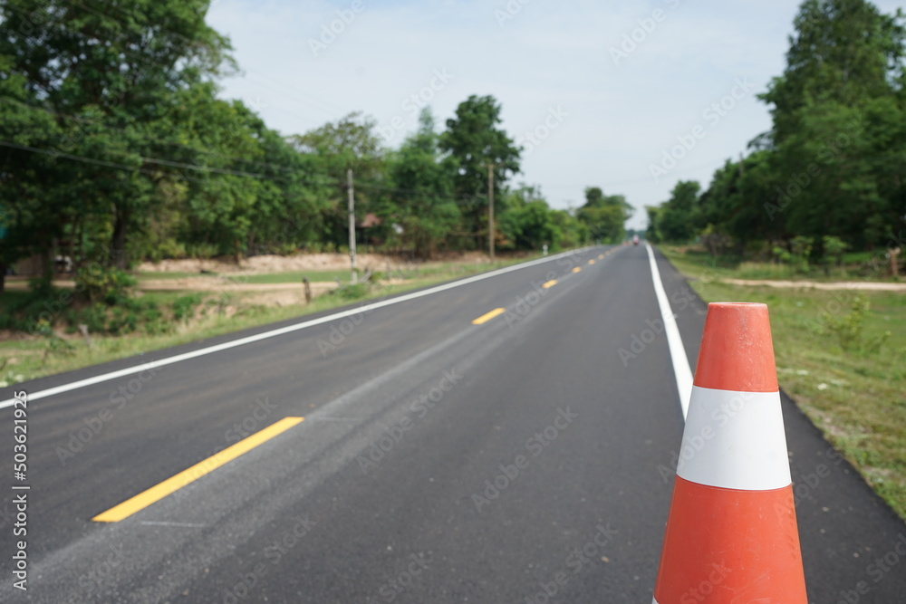 Red rubber cones are placed in the paved road. Red rubber cones are placed in the paved road.