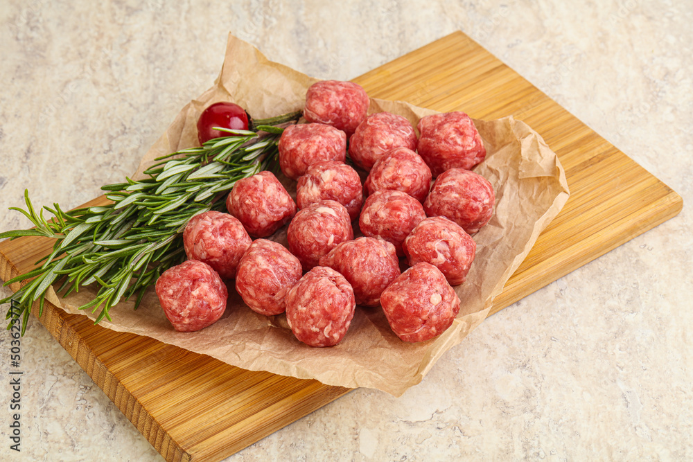 Raw uncooked beef meatballs served rosemary Raw uncooked beef meatballs served rosemary