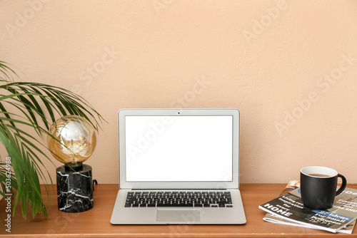 Modern laptop, lamp, cup an...