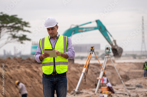 Billede på lærred Surveyor engineer wearing safety uniform ,helmet and radio communication with eq