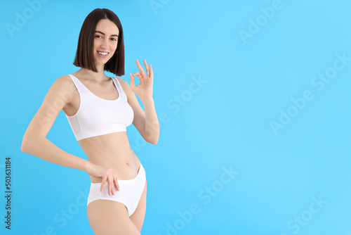Concept of weight loss, young woman on blue background