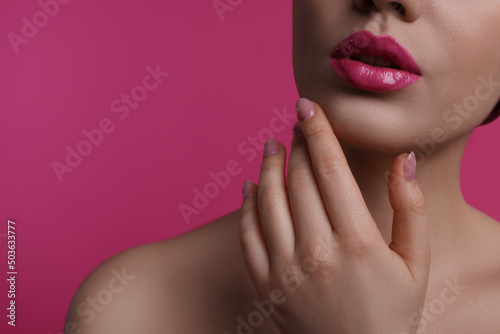 Closeup view of woman with beautiful full lips on pink background, space for text