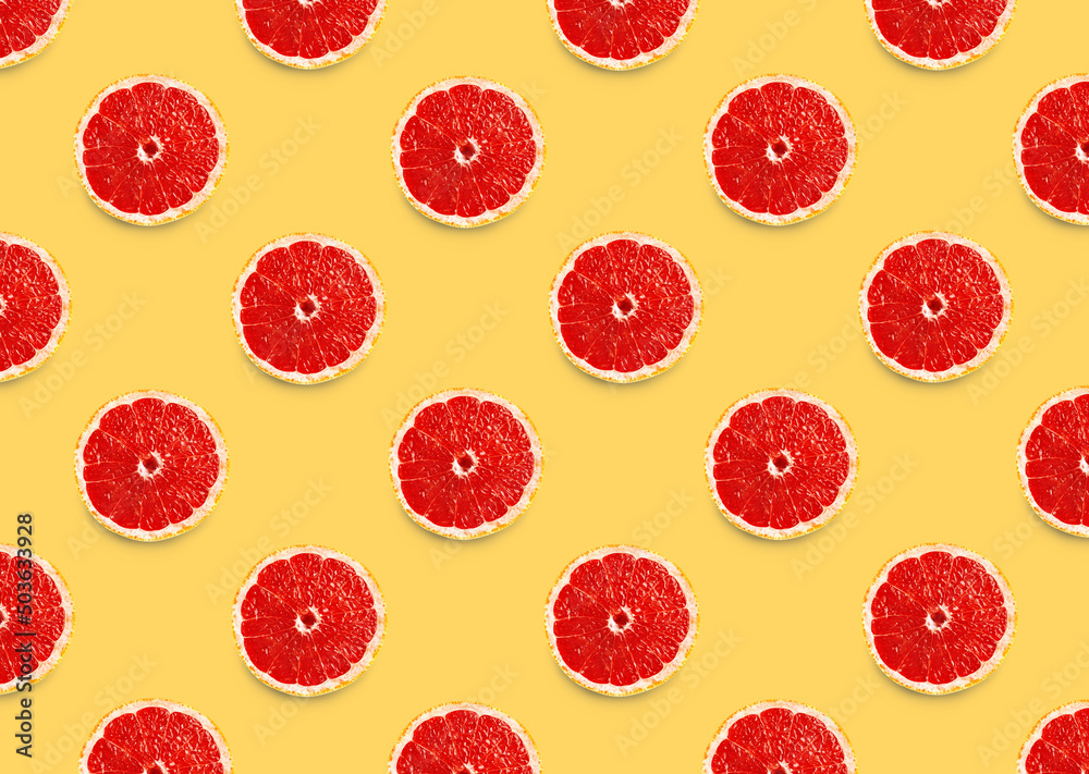 Many fresh ripe slices of grapefruits on yellow background, flat lay. Seamless pattern design