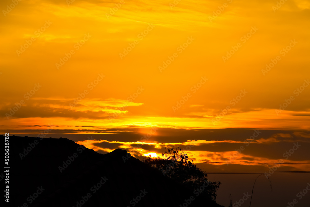 Sunrise sky vast background with silhouette of house roof and tree