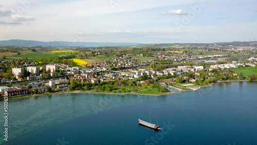 Flying Over The Panoramic View Of Preverenges Town In East Morges Facing Its Turquoise Waterfront In Vaud, Switzerland. Wide Aerial photo