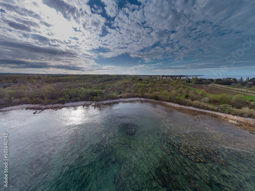 Wide panorama of a beach close to Novigrad with visible tourquoise water and blue sky with clouds.Beautiful panorama of a istrian beach.