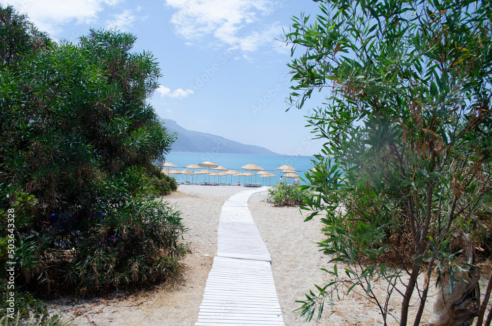 Fototapeta premium Oludeniz Beach, which is famous for its sandy beach and blue sea, is where paragliders jumping from Babadag land.