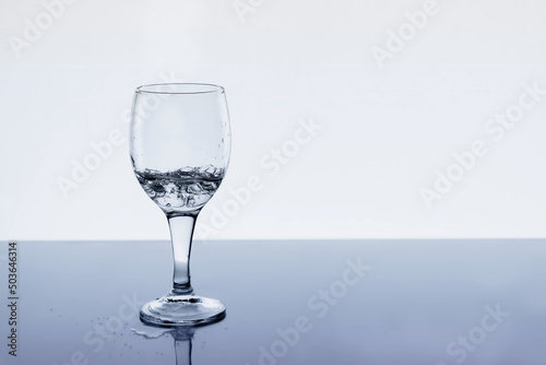 Wine glass with water and drops on the table  copy space