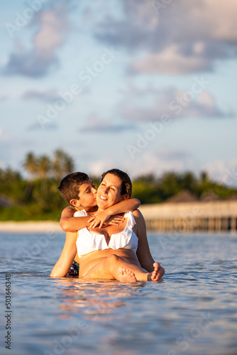 Son hugging his mother on the beach