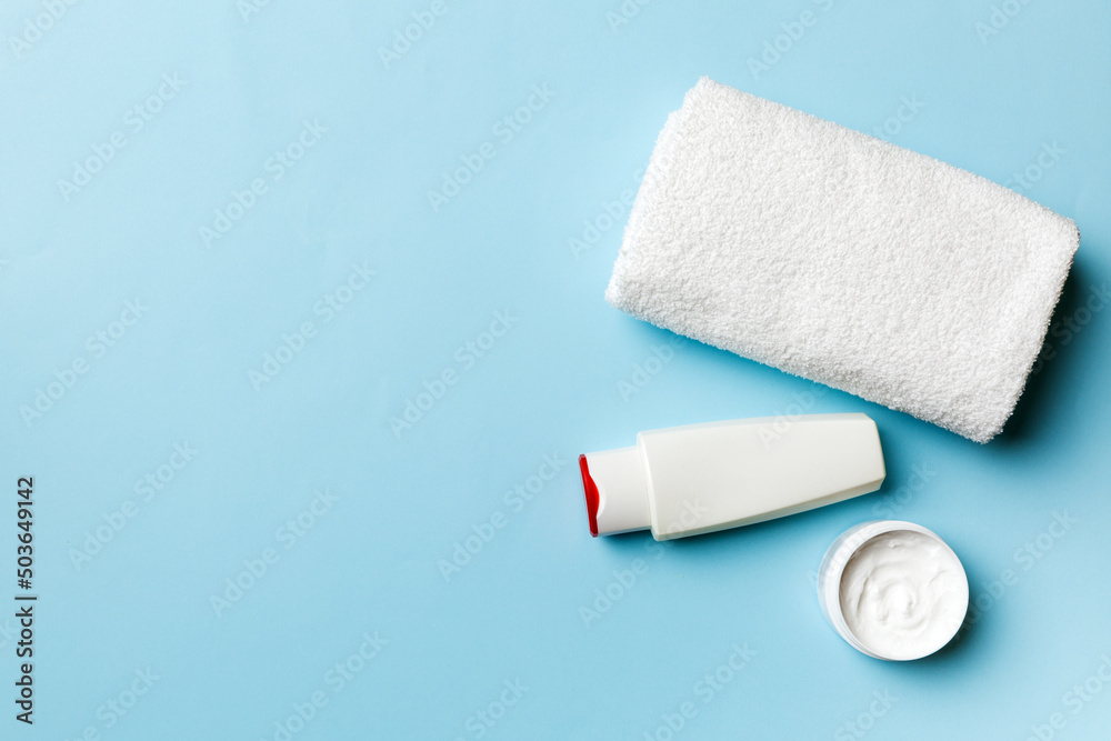 Fototapeta premium Cosmetic shampoo bottle mockup with towels on a colored table. Bathroom background, toilet accessories for hand and body care