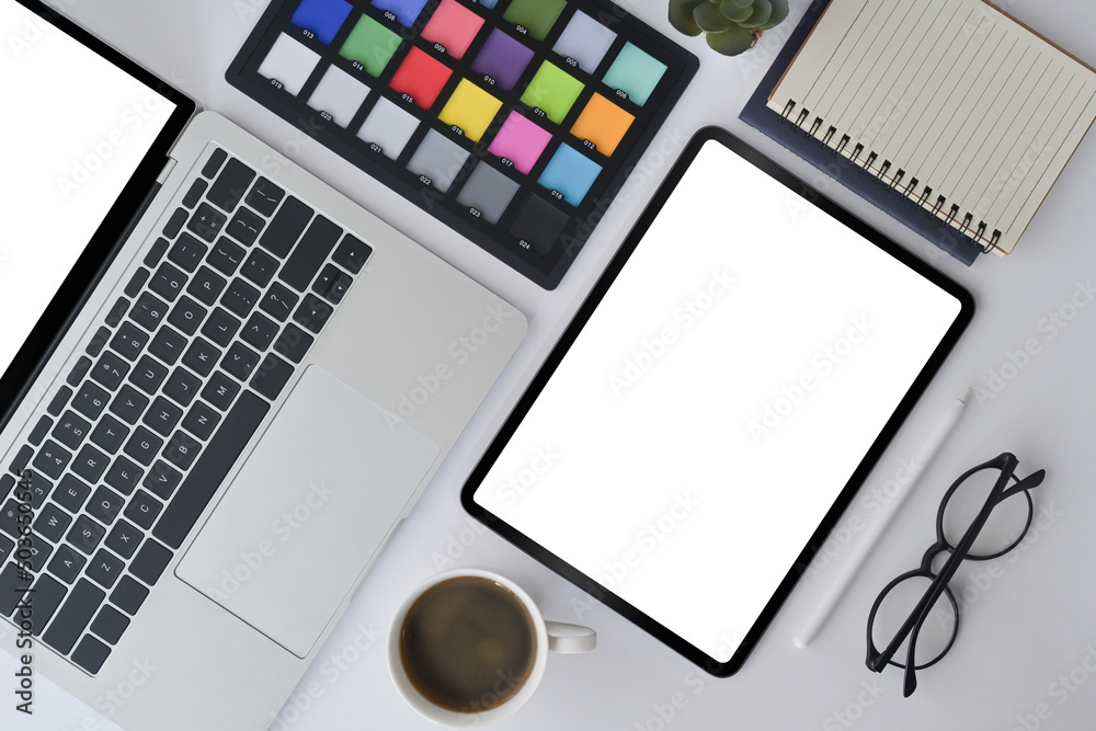 Graphic designer workplace with digital tablet, laptop and color swatches. Top view. Graphic designer workplace with digital tablet, laptop and color swatches. Top view.