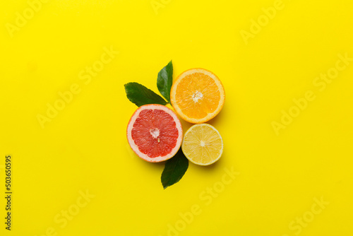 Fruit background. Colorful fresh fruits on colored table. Orange, lemon, grapefruit Space for text healthy concept. Flat lay, top view, copy space