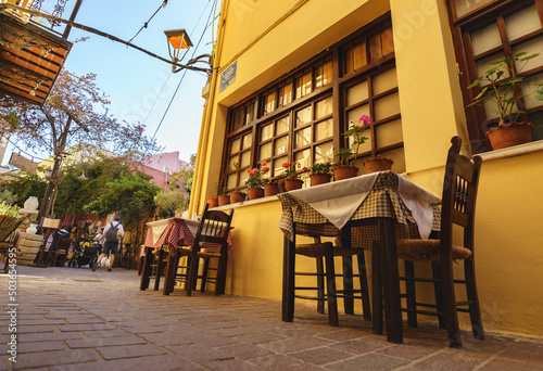 Fototapeta Naklejka Na Ścianę i Meble -  Greek tavern tables outdoors at the old street of Chania city.