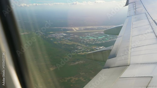 Airplane Flying Over Leaving Cancun International Airport Seen From Passenger Window With Airplane Wing In The Foreground. photo