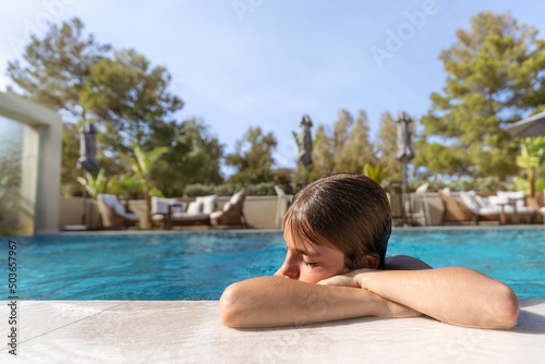 Cute 11 year old boy having a good time in the pool on a summer day © 22Imagesstudio