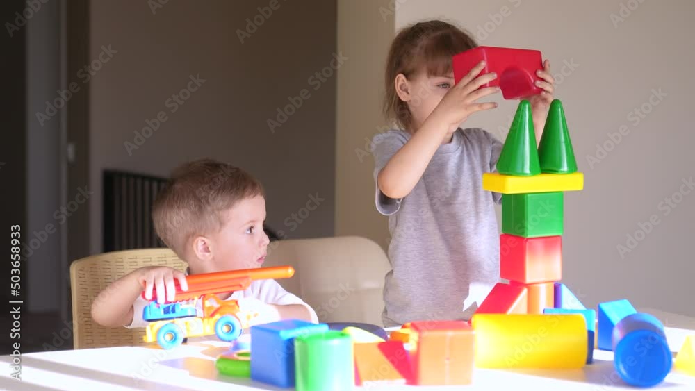 kids girl and baby play in kindergarten. a group of children play toys cubes and cars on the table in kindergarten. happy family preschool education concept indoor. nursery baby toddler home kids girl and baby play in kindergarten. a group of children play toys cubes and cars on the table in kindergarten. happy family preschool education concept indoor. nursery baby toddler home
