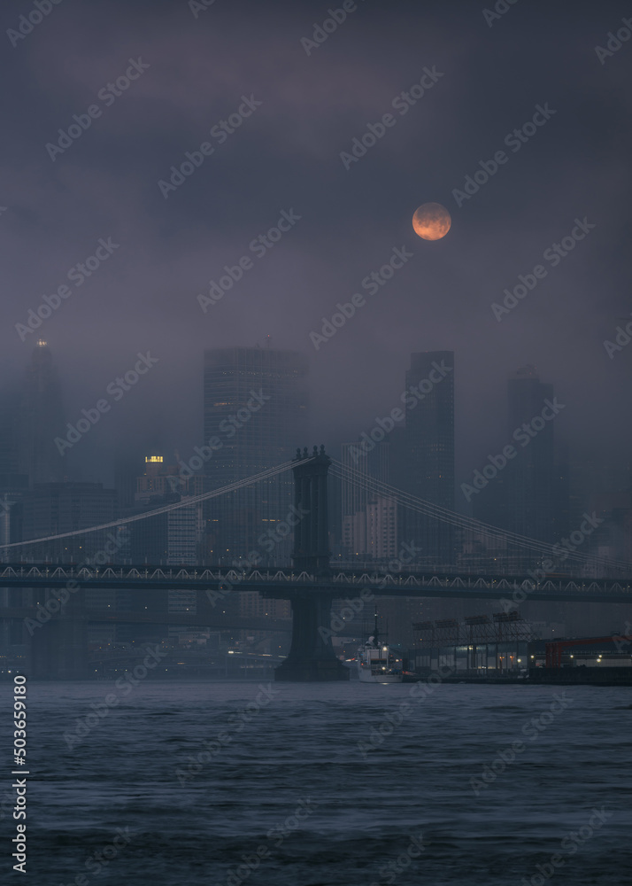 Full moon over the financial district on a foggy morning