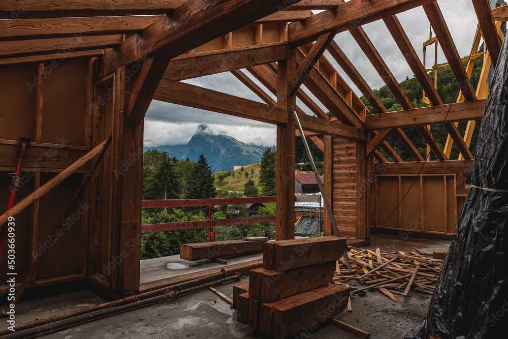 wide shot of inside a wooden house being built floor wet from rain