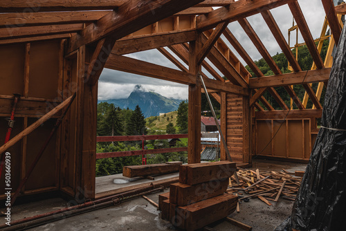 wide shot of inside a wooden house being built floor wet from rain