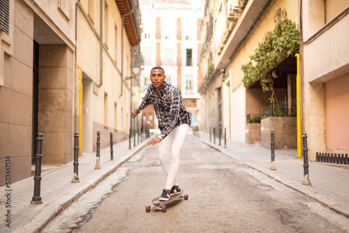 young african american man rollerblading with long board on the street © luisrojasstock