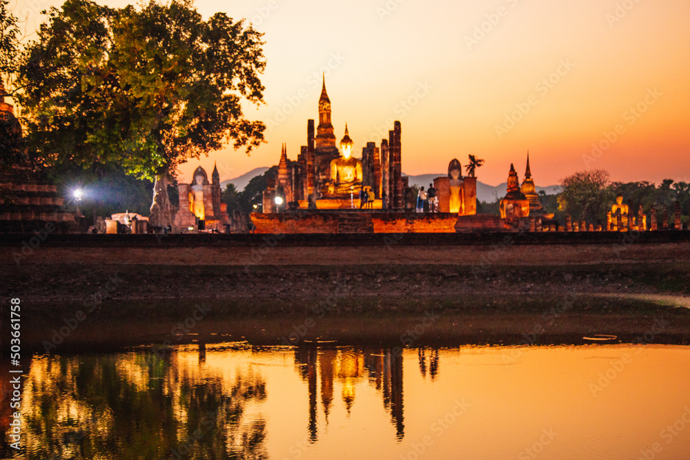 Naklejka premium Sunset at Wat Mahathat buddha and temple in Sukhothai Historical Park
